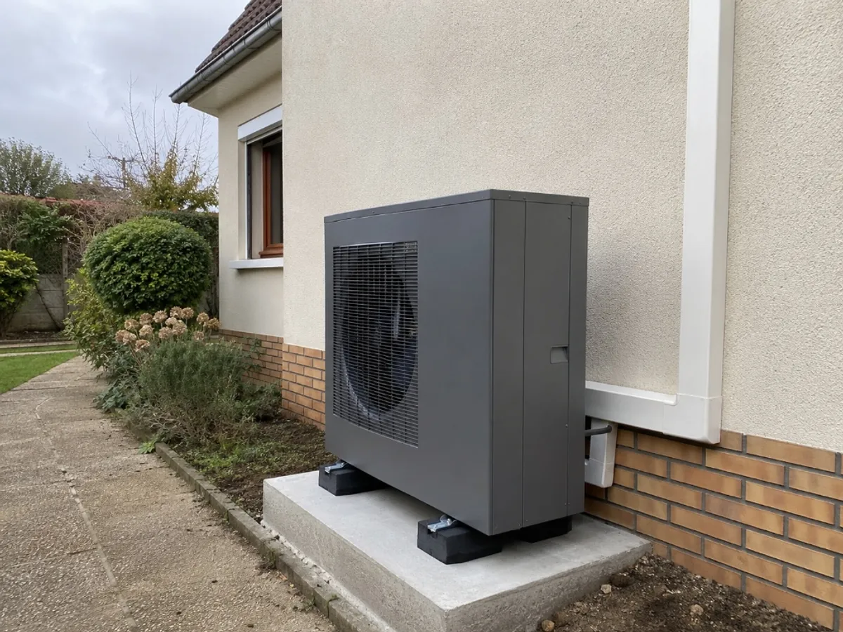 Pompe à chaleur air-eau installée sur dalle béton à l'extérieur d'un pavillon en Île-de-France